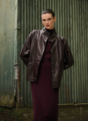 Woman wearing an aubergine jacket from the Japan TKY fall/ winter 2024 collection