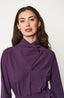 Woman wearing a purple blouse against a white background