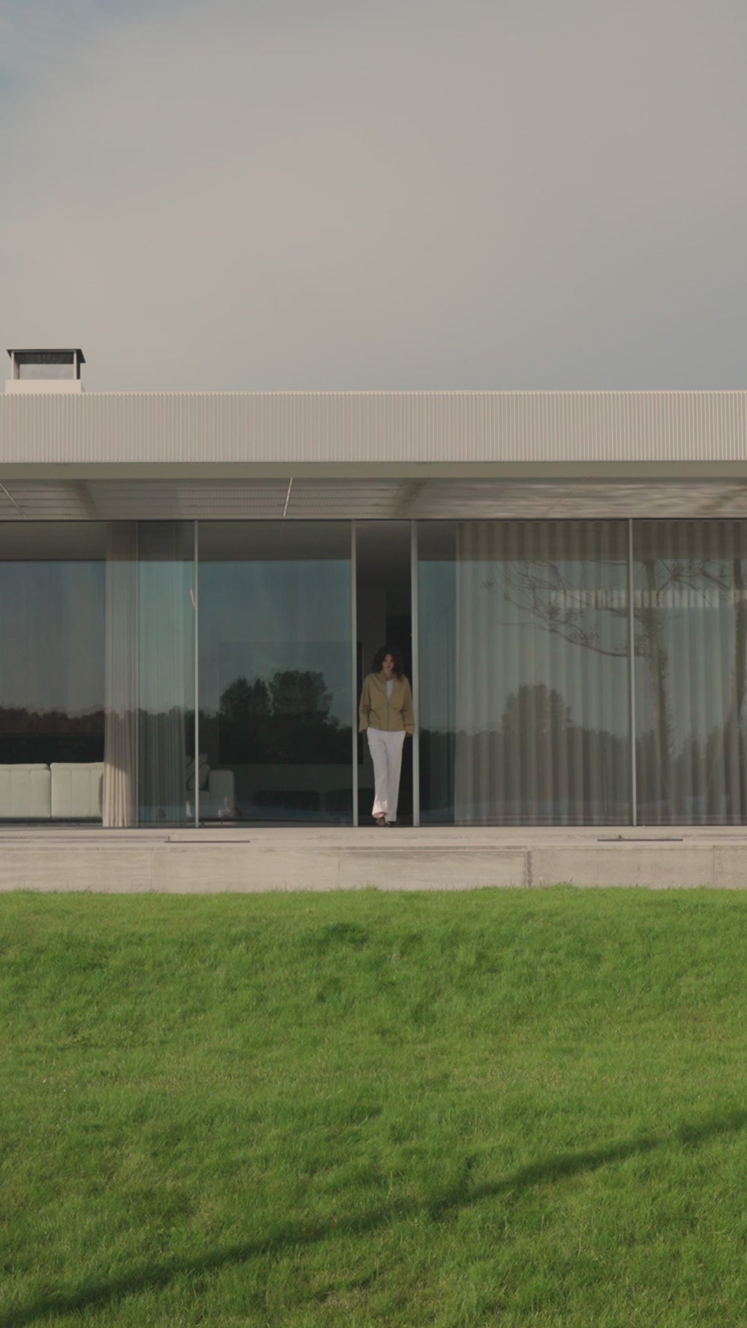 Woman wearing sand jacket en white pants from the Japan TKY Spring Summer 2025 collection