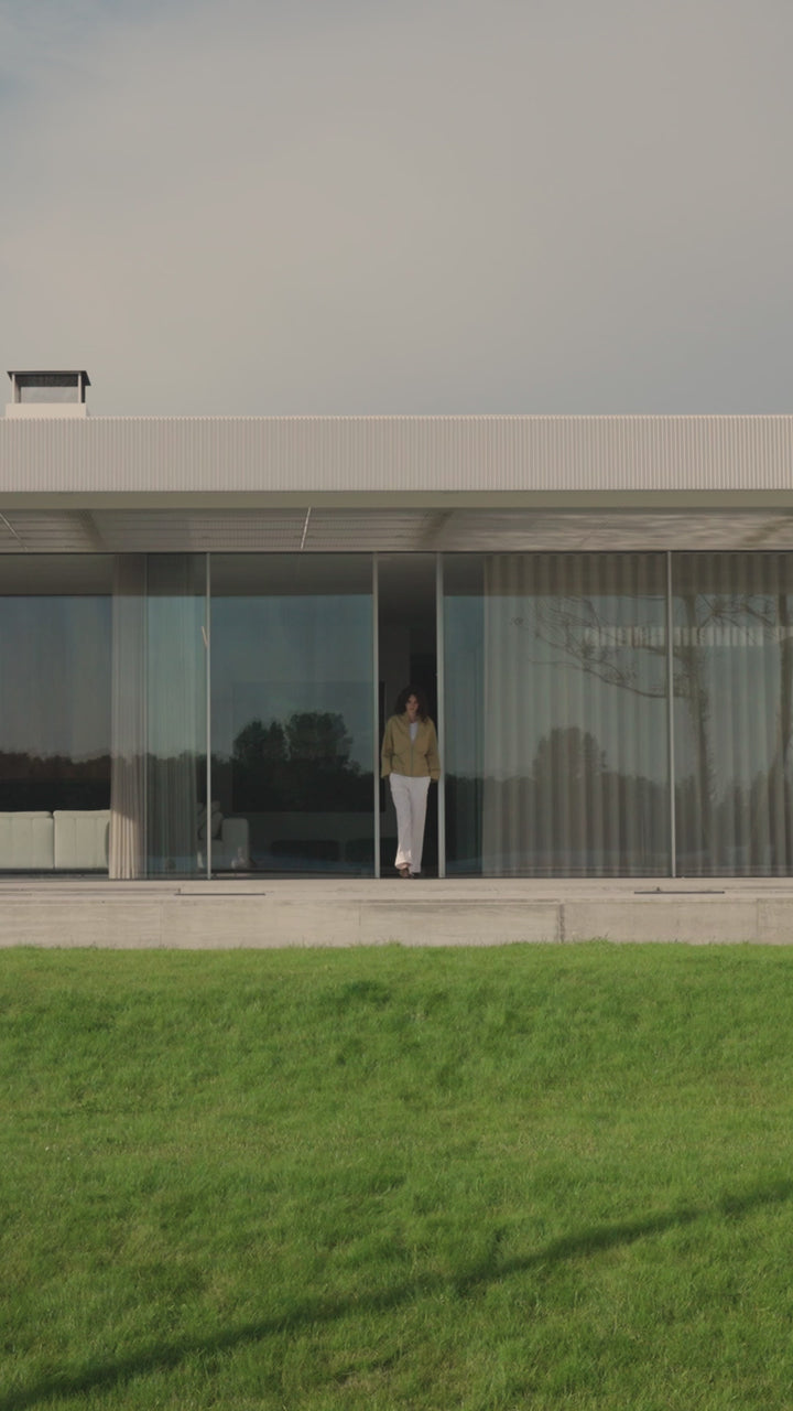 Woman wearing sand jacket en white pants from the Japan TKY Spring Summer 2025 collection